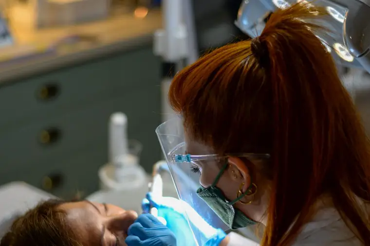 Dentista realizando tratamento de canal com instrumentos endodônticos