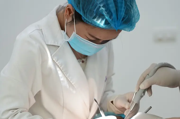Equipe odontológica em procedimento cirúrgico de extração