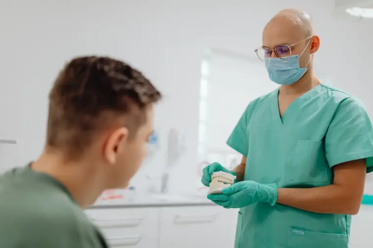 Dentista orientando o paciente no consultório