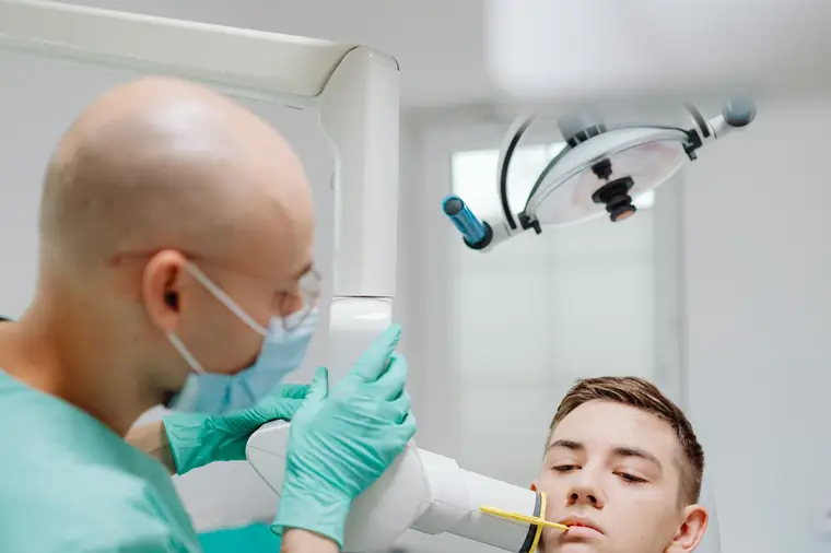 Paciente realizando radiografia odontológica em clínica